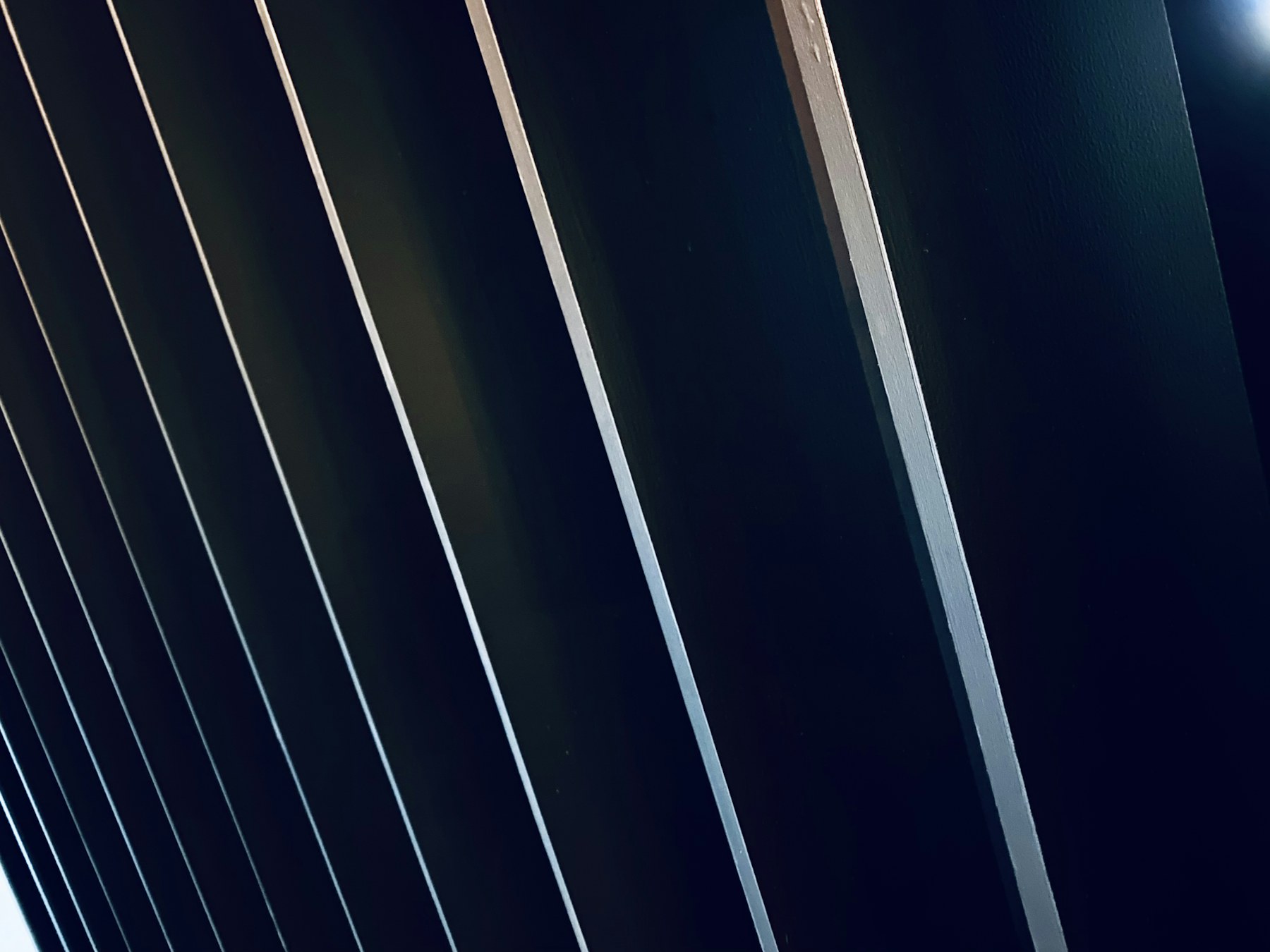 Dark blue architectural fins crossed by narrow bands of light in Valencia