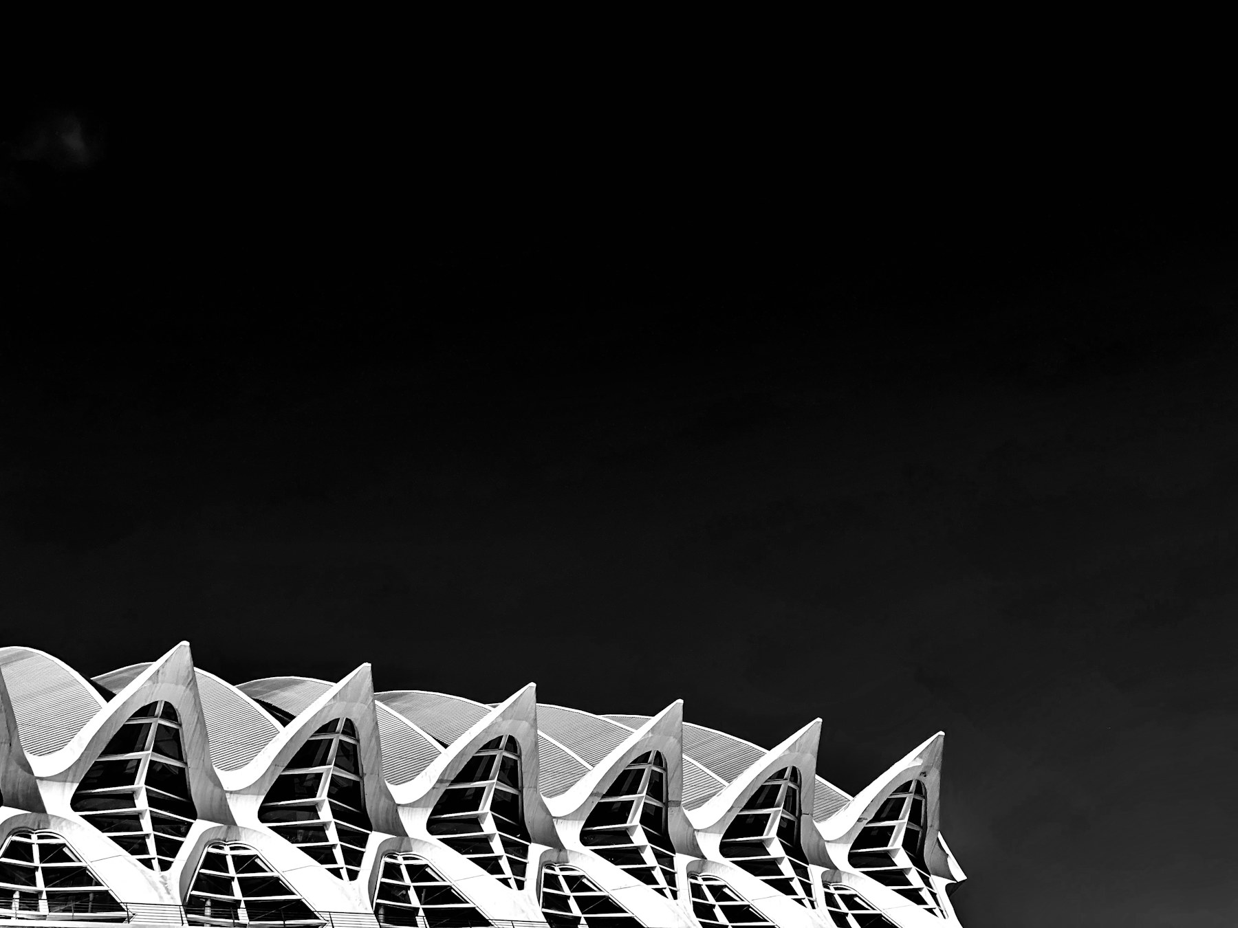 White repeating architectural peaks rising beneath a deep black sky in Valencia
