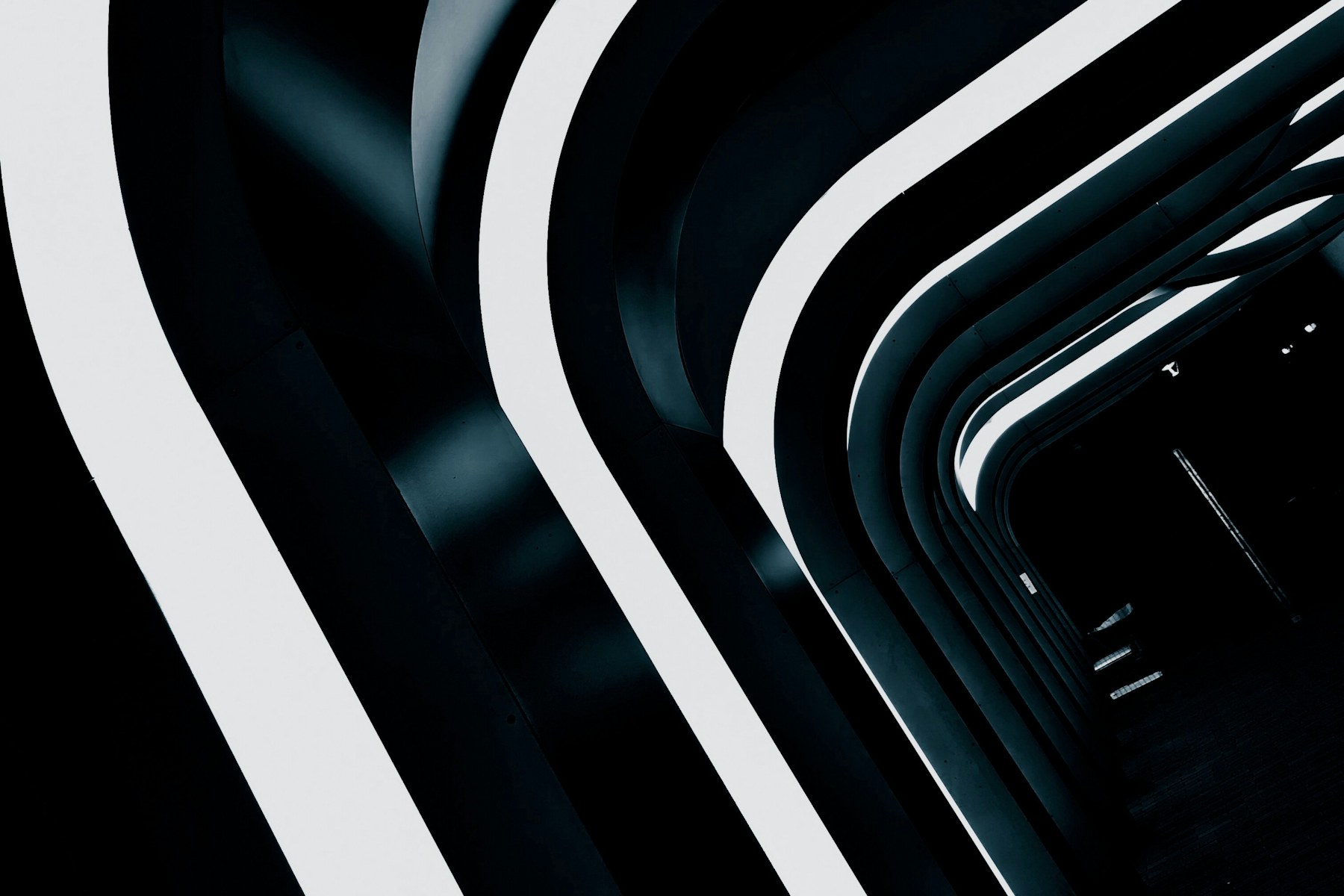 Black and white architectural arcs sweeping through a dark entrance in Toronto
